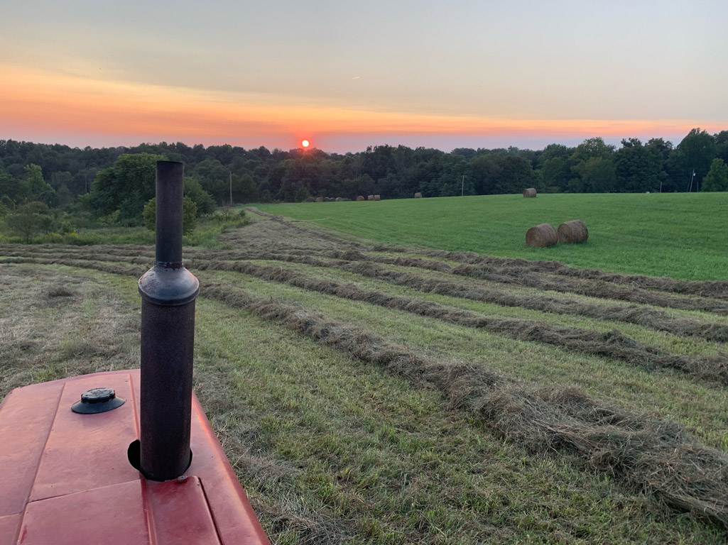 tractor and hay at sunset